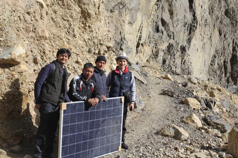 Команда ISOC и жители села Зардалы несут солнечную панель через узкие горные тропы